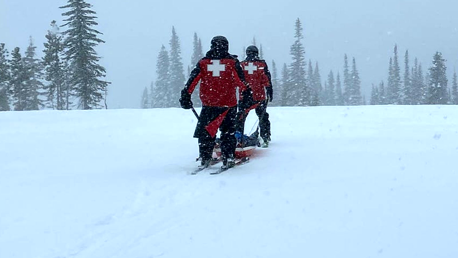 Ski patrollers skiing a rescue toboggan